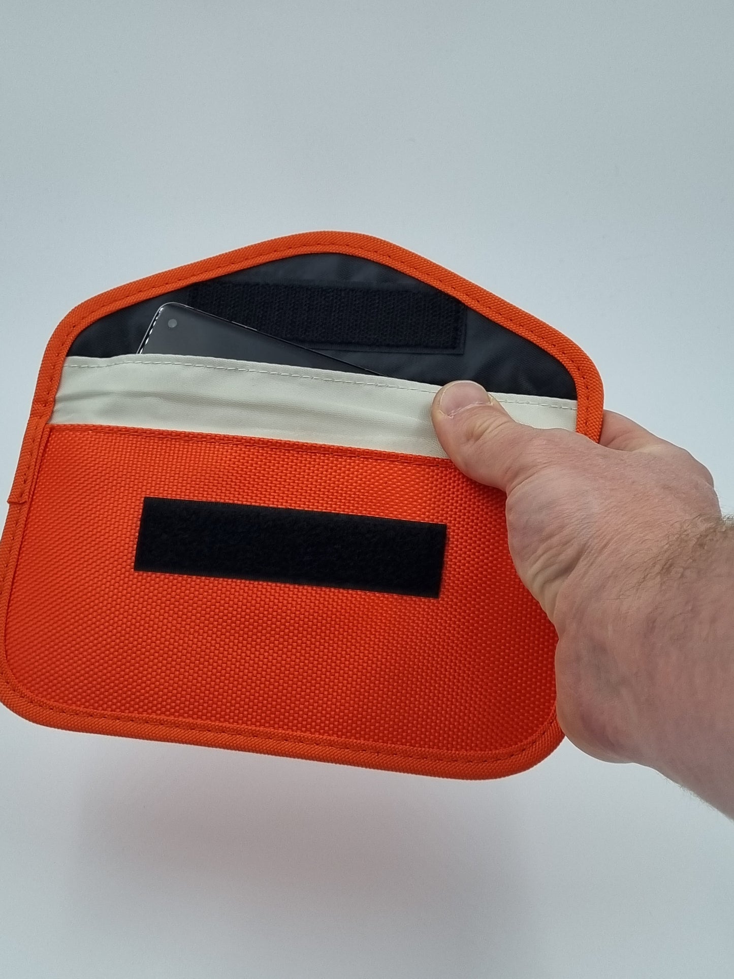 Orange Faraday phone pouch featuring RFID blocking and EMF protection, providing signal shielding and device protection